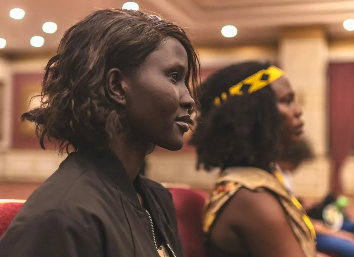 Two women in the audience listen attentively during a conference session